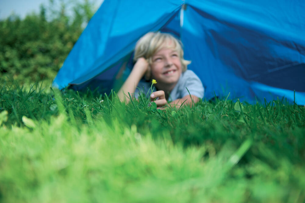 Kind vor einem Zelt 