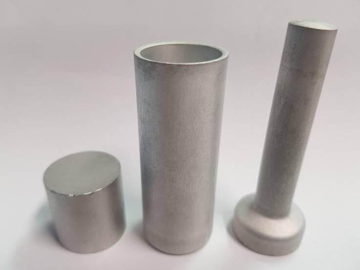 Rohteil (links) und hieraus kaltmassivumgeformte Versuchsteile, napfrückwärts- (Mitte) und vollvorwärtsfließgepresst (rechts)  © ZWEZ-CHEMIE GmbH, Lindlar 